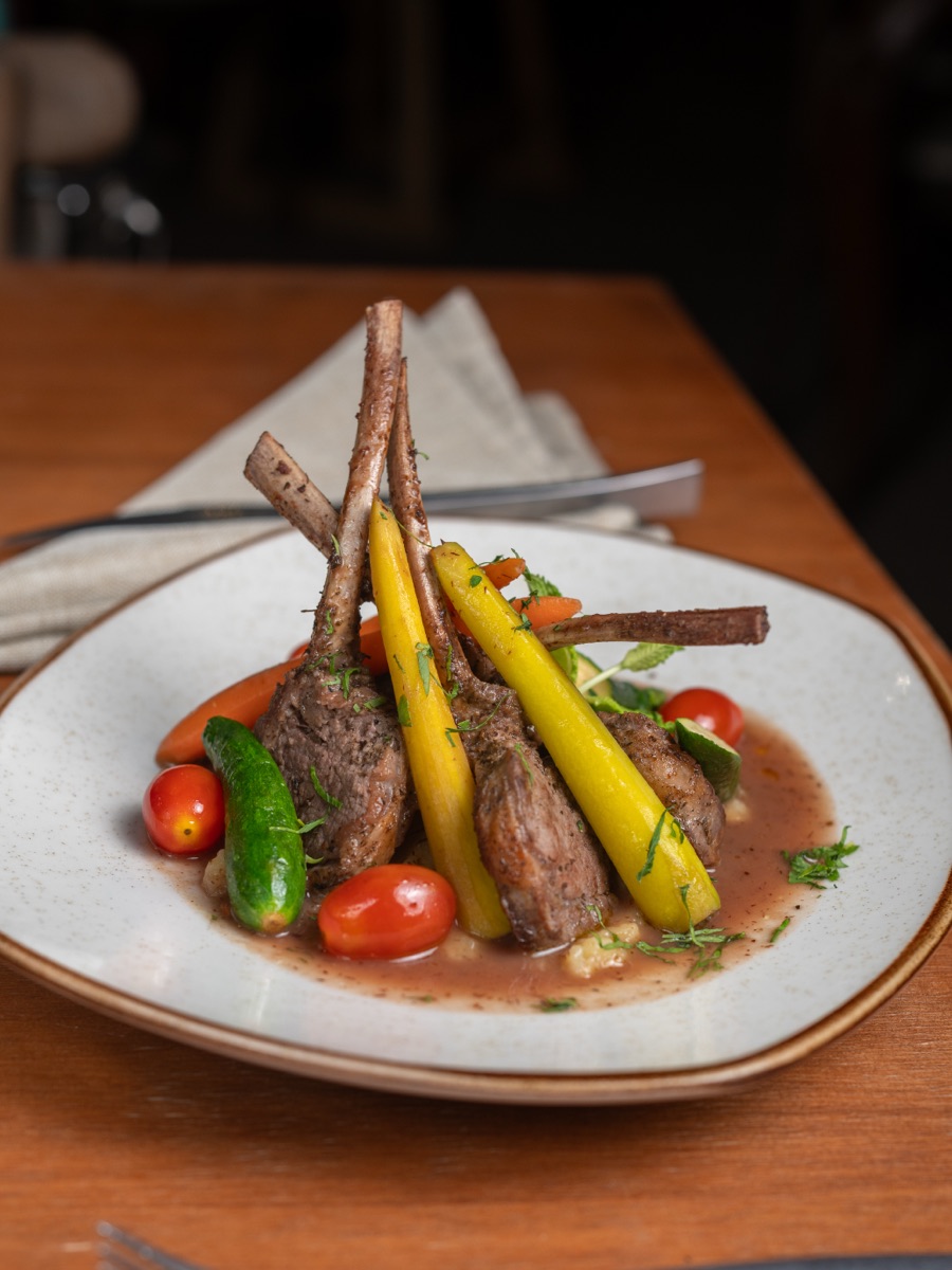 Rack of lamb with baby carrots, zucchini and cherry tomatoes.