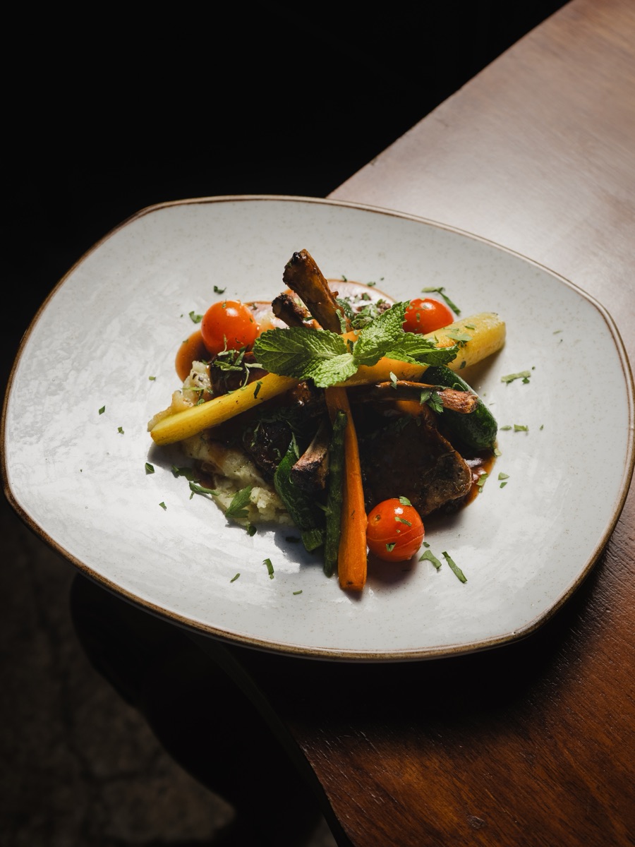 Plated dish with roasted vegetables and fresh herbs.